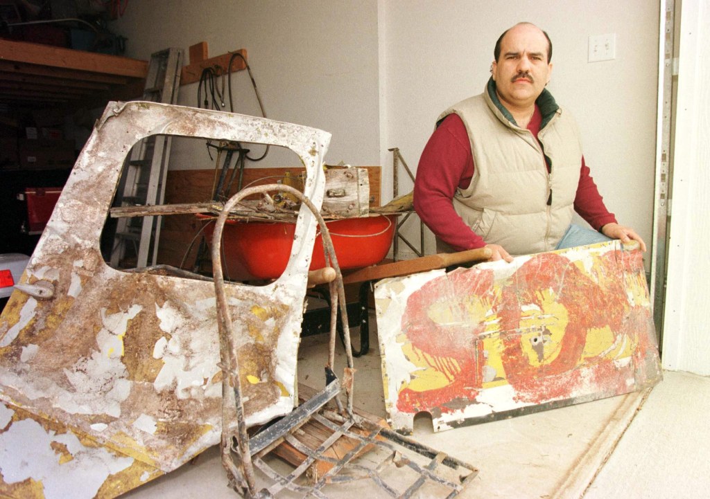 Frank Flores with parts of his father's crashed plane in his Willard, Missouri garage.